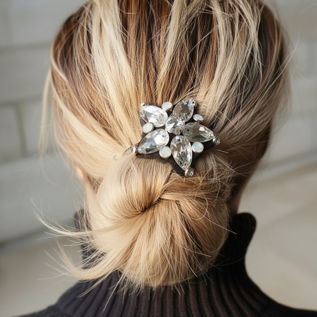 A hair tie with a crystal star design being used to secure a bun hairstyle.